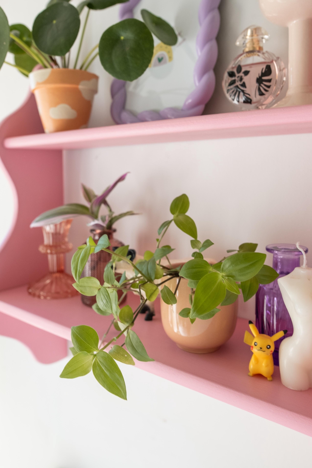 Étagère rose bubblegum remplie d’accessoires déco colorés : figurine Pikachu, bougeoir en verre, mini vase et plantes dans des pots pétillants. Idéal pour créer un intérieur dopamine plein de vie et de bonne humeur, où chaque objet apporte fun et personnalité.