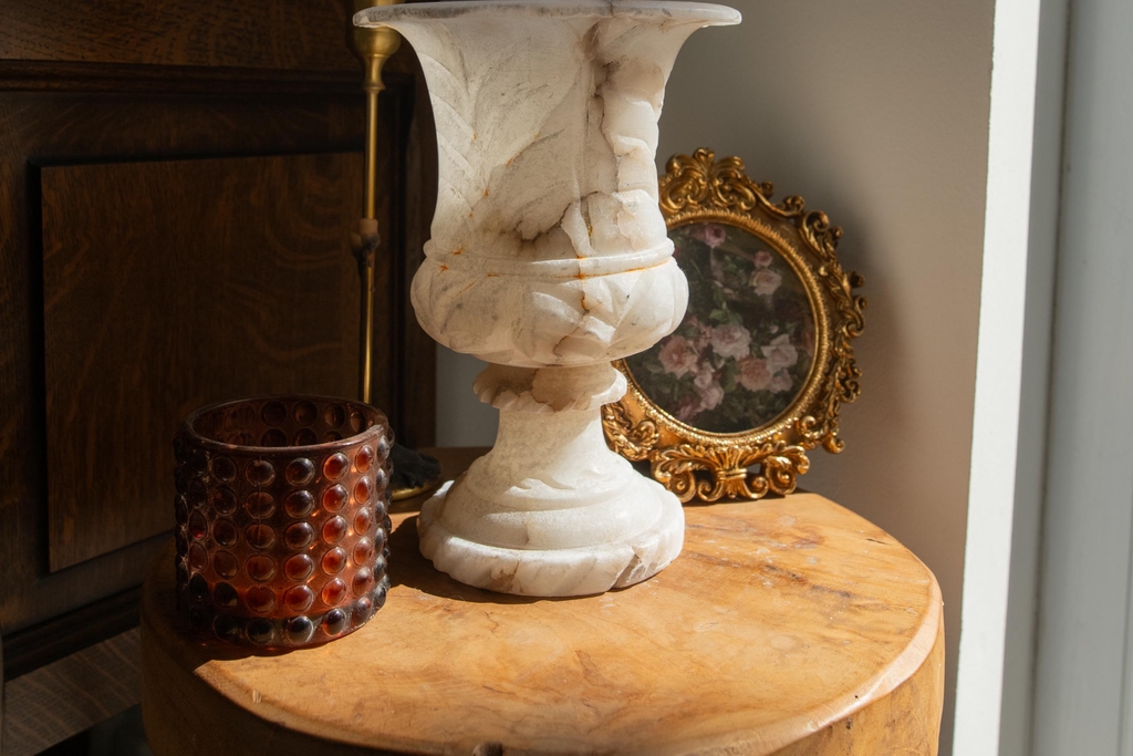 Ambiance Mystic Corner avec vase en marbre, pot en verre teinté et cadre doré à l’illustration florale. Plantes et accessoires déco soigneusement choisis pour créer un intérieur mystérieux et élégant. Idéal pour les amateurs de déco sombre, chic et pleine de caractère, qui aiment mélanger textures naturelles et objets uniques.
