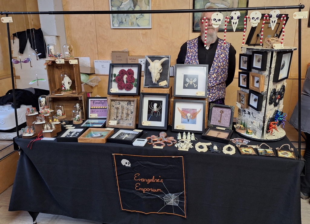 A photograph of Evangeline's Emporioum set up at an event at Reading Biscuit Factory. The stall is full of Gothic, Steampunk, and Alternative art and curios.