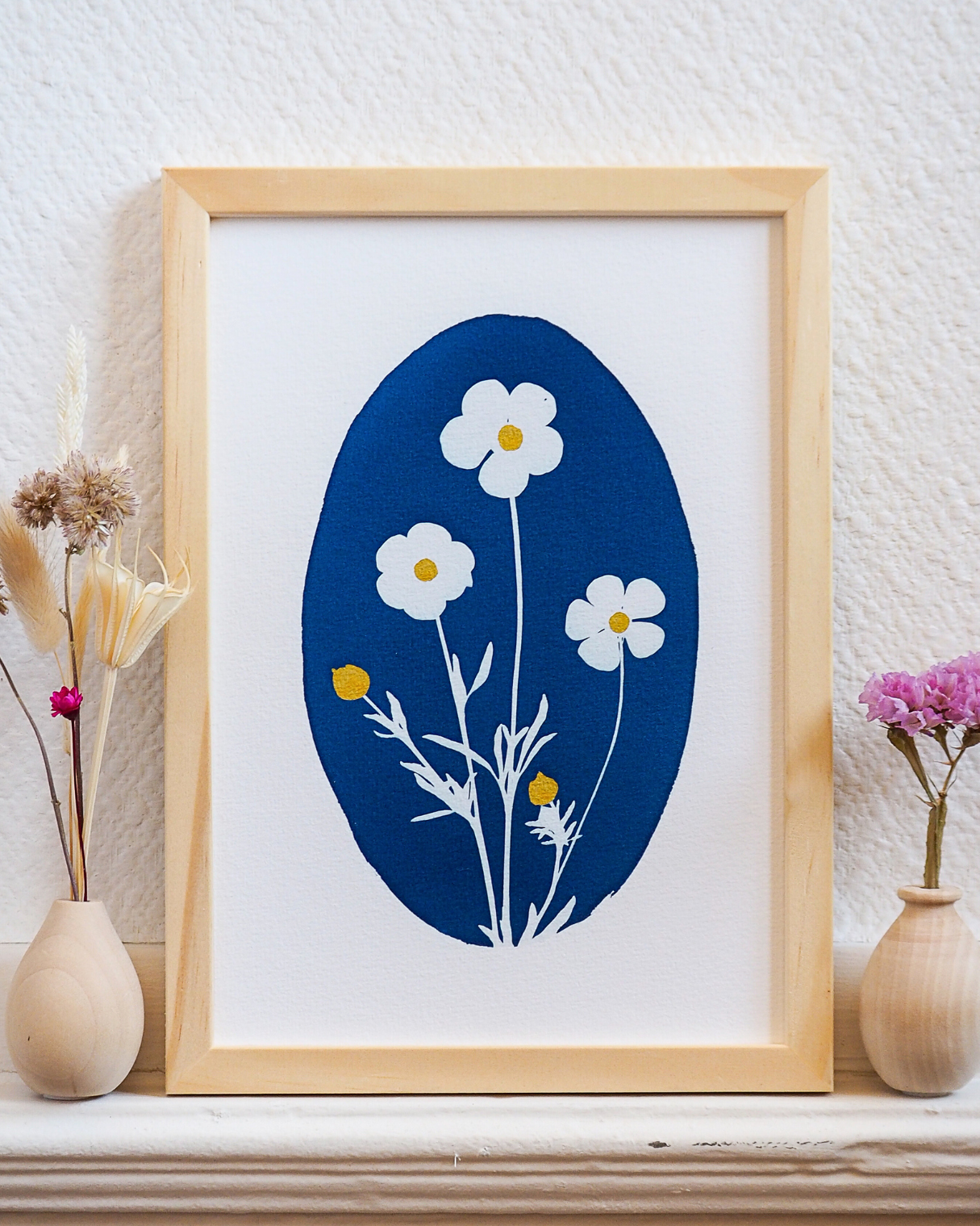 Tirage obtenu par la méthode du cyanotype, représentant l'empreinte végétale de boutons d'or. Le centre de la fleur et son bouton sont dorés.
Ce tirage est parfait pour une décoration boho chic et champêtre de votre intérieur. Il vous permettra de vous créer un intérieur apaisé sur le thème de la nature.