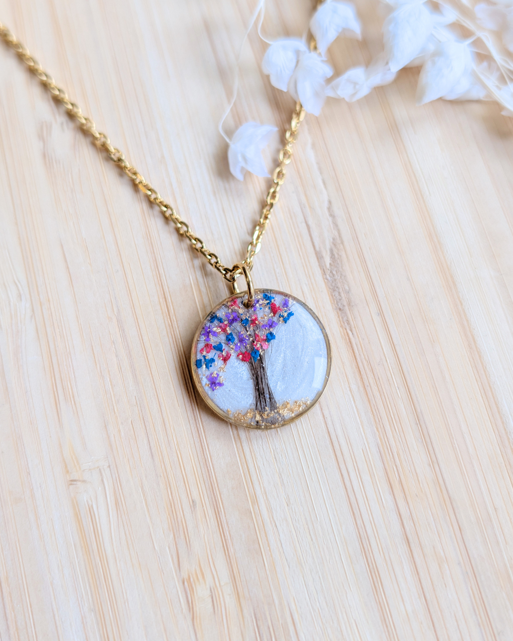 Collier personnalisé avec une mèche de cheveux d’un proche décédé des fleurs séchées, feuille dorée et fond blanc nacré en résine
