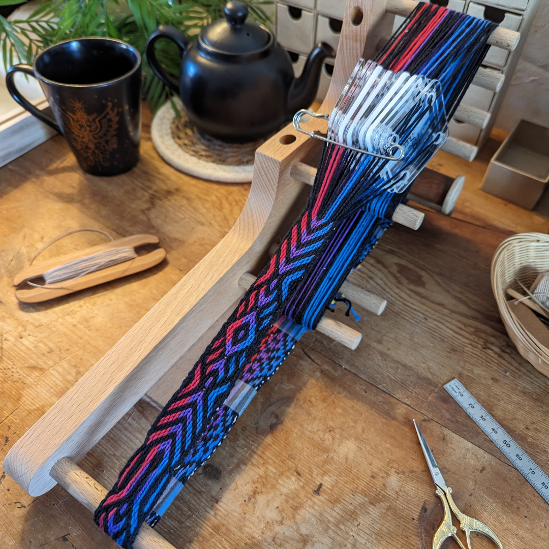 photo du métier à tisser, avec motif aux couleurs du drapeau bi en cours de tissage