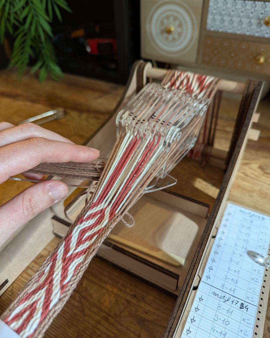 Photo d'un métier à tisser avec un galon tissé aux cartes en cours de tissage