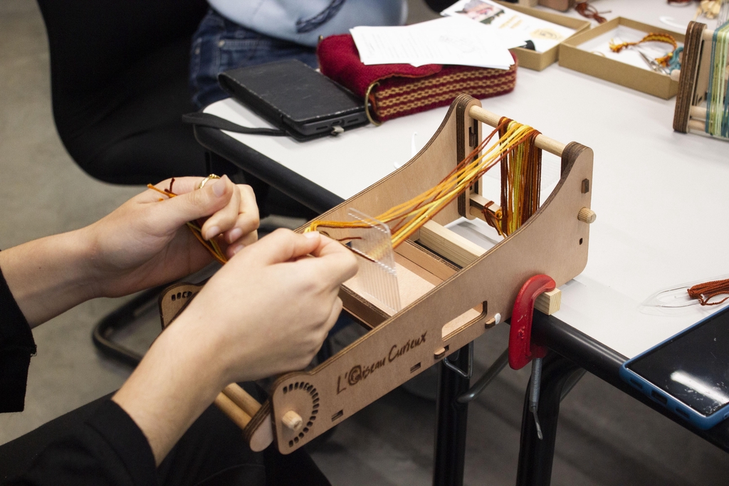 Photo du montage de fils sur un métier à tisser de l'Oiseau Curieux lors d'un atelier