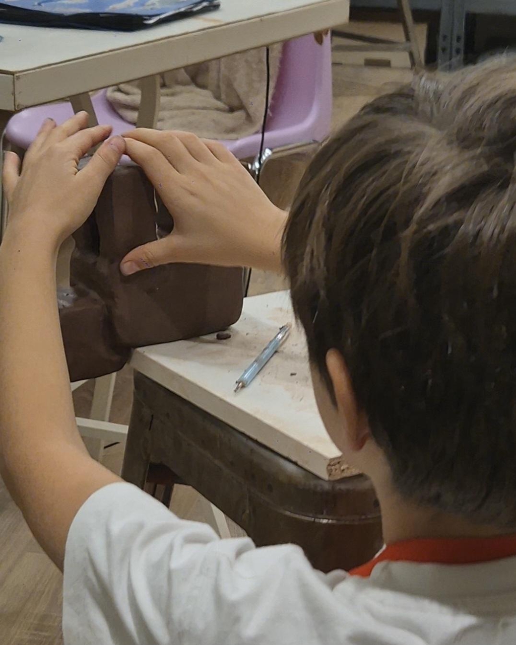 Photo de mains d'enfant et de sa sculpture en grès