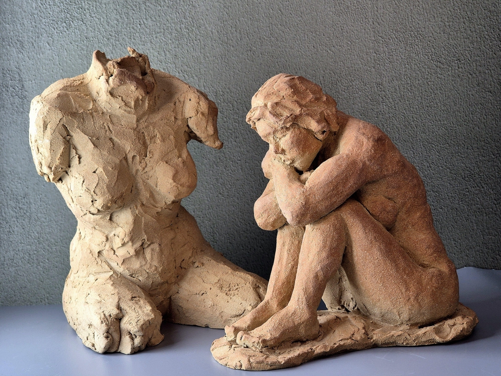 Deux sculpture en grès d'un torse de femme et d'une femme assise et rêveuse