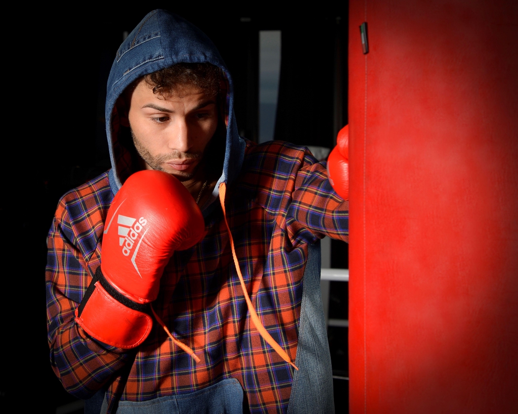 Matteo Lecca, campione italiano di pugilato, brand testimonial Marita Balàzs che indossa giacca in denim riciclato con dettagli punk, moda sostenibile unisex made in Italy - ritratto professionale su sfondo bianco