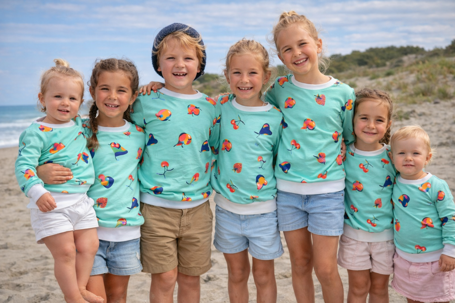 Enfants sur le bord de mer portant tous des sweat-shirts confectionné à la main Octave et camélia