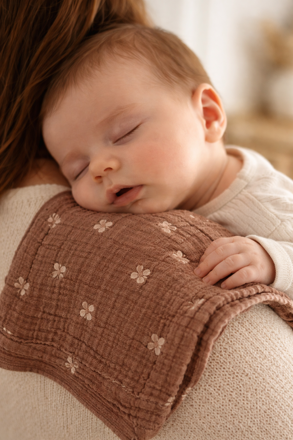 Tête d'un enfant posé sur l'épaule de sa maman et sur un Launch de coton en double gaz confectionné par Octave et camélia