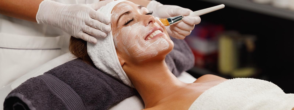 Junge Frau lächelt und genießt Gesichtbehandlung in Laura Bernstein® Kosmetik Studio. Eine  ruhige Atmosphere.