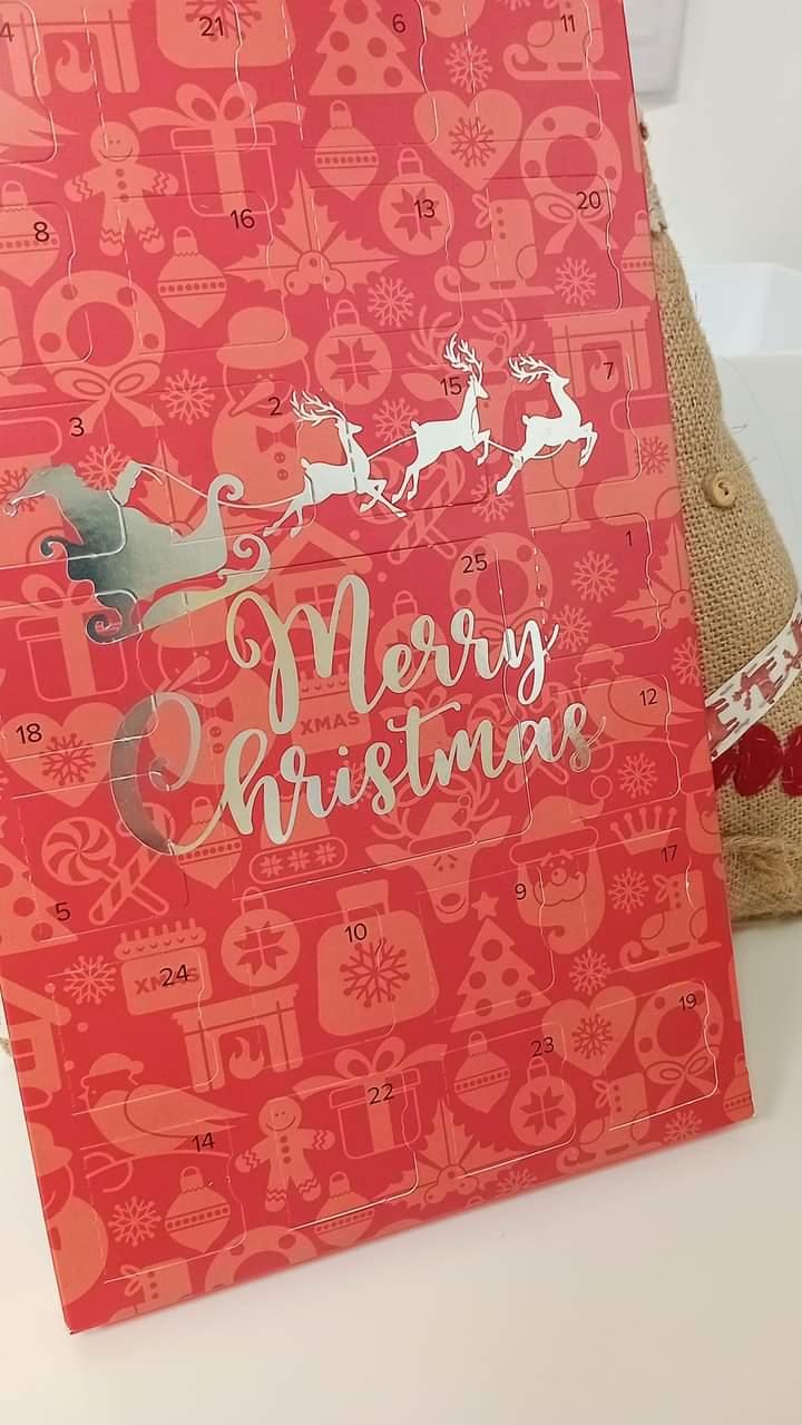 Robson's retreat advent calendar. A red cardboard box exterior. Merry Christmas is written across the front in shiny letters. There are 25 doors to open 