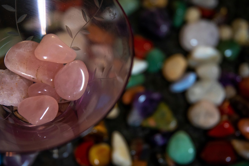 Sélection de bijoux artisanaux Slowfil en micromacramé et pierres naturelles de lithothérapie (Améthyste, Labradorite, Quartz) disposés sur un support minéral brut.