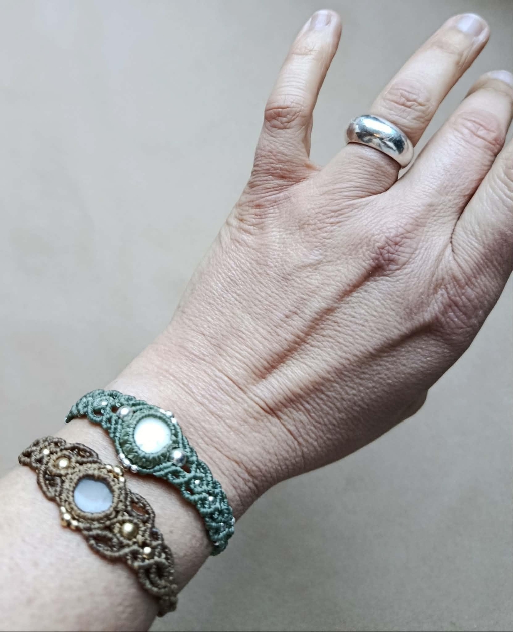 Assortiment de bracelets artisanaux Slowfil en micromacramé et galets naturels de Bretagne, avec fermoirs ajustables et perles dorées.