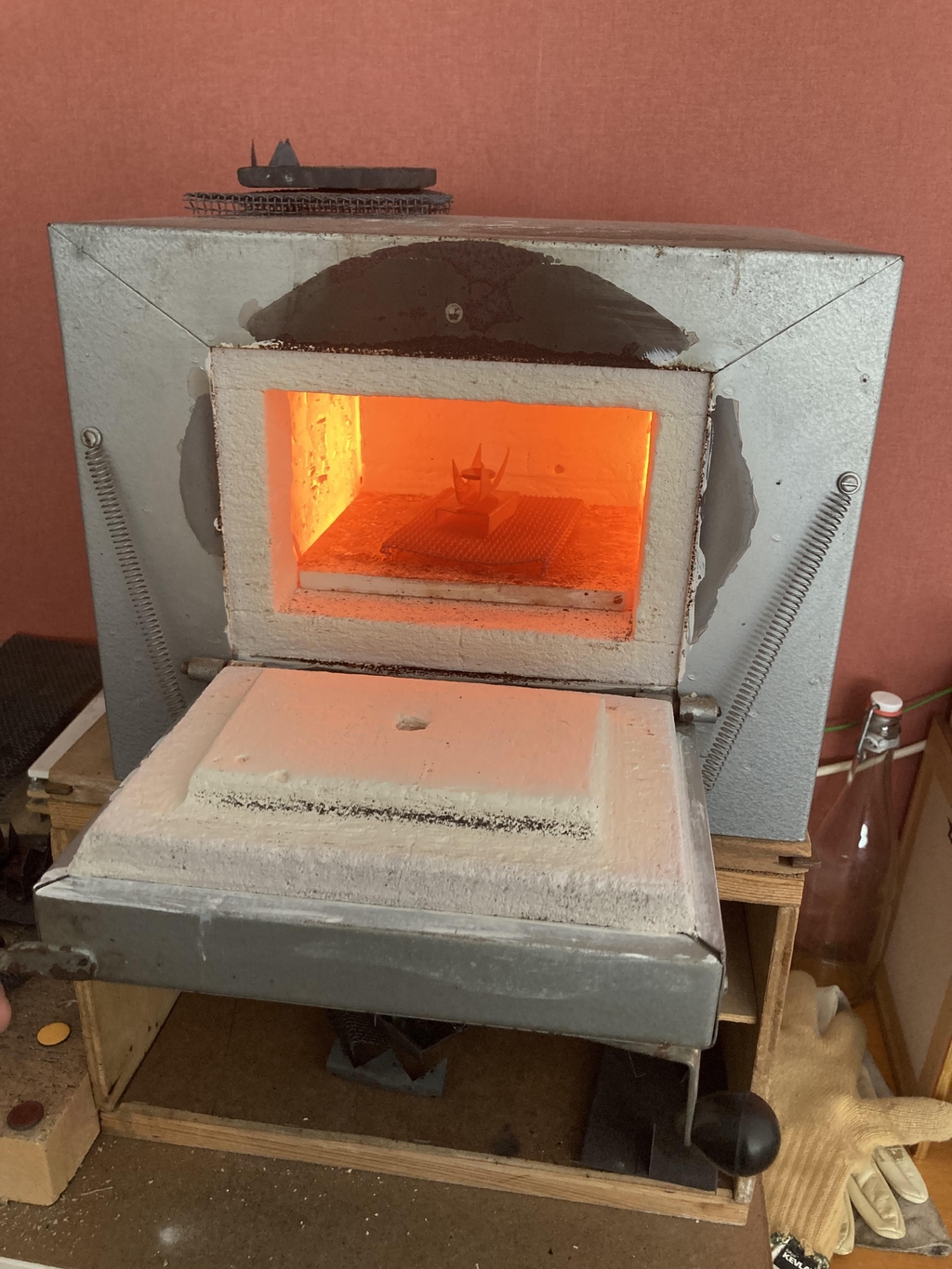 le four ouvert et la lueur orange qui s'en dégage. l'émail cuit autour de 800°