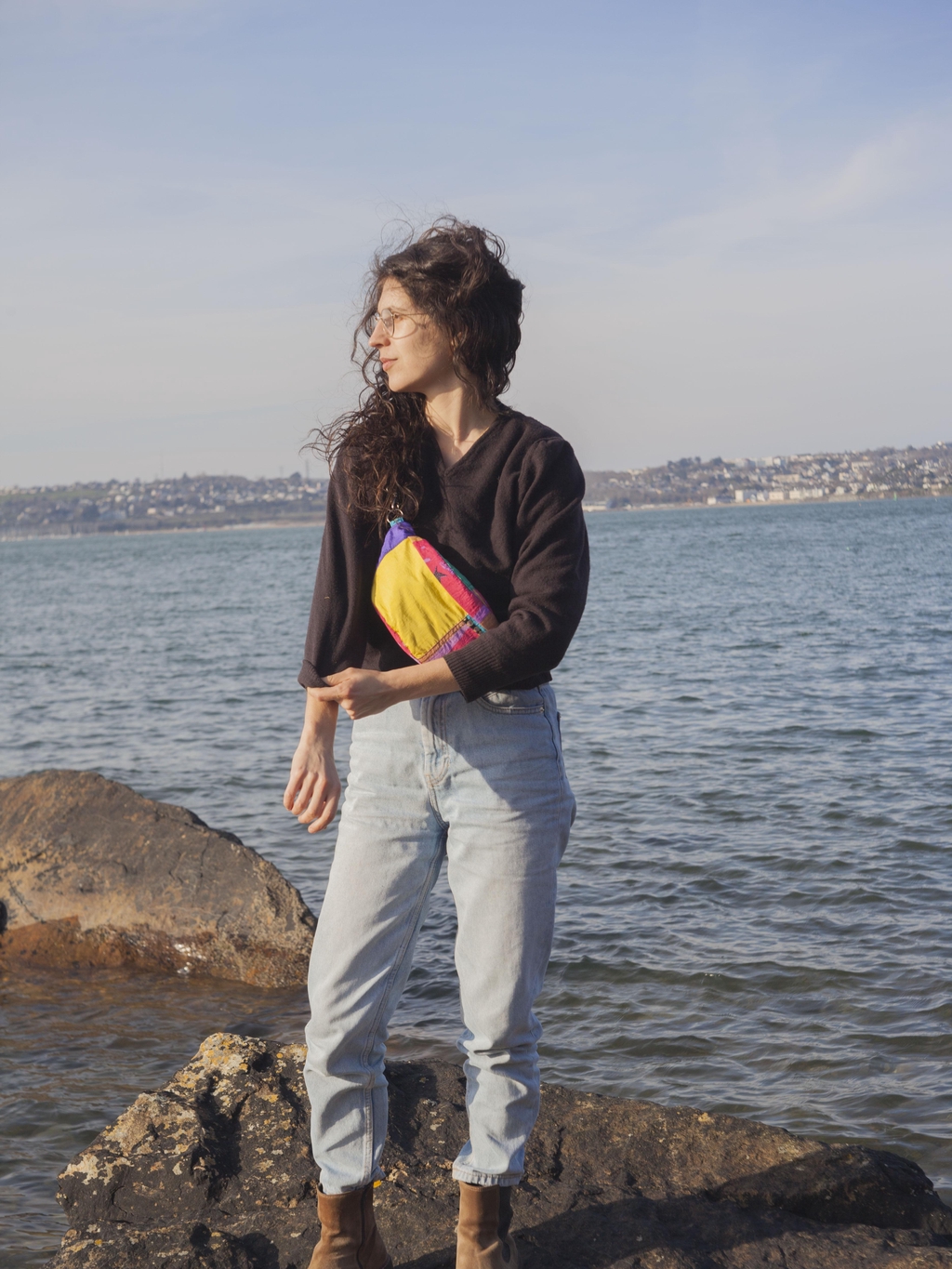 Image de la créatrice à la mer portant une banane colorée.