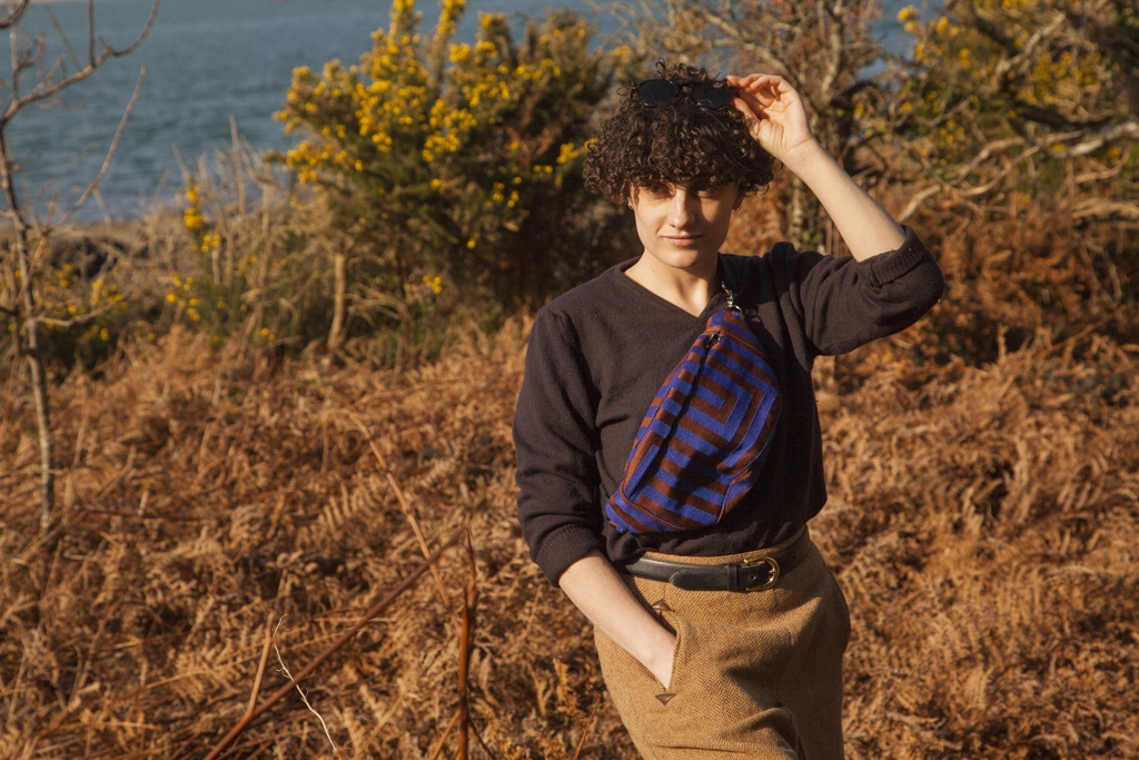 Personne dans la nature portant une banane géométrique violette et marron.