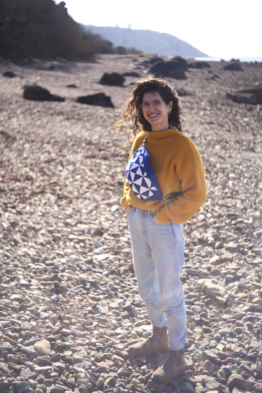 Image de la créatrice accroupie dans un parterre d'ajonc et portant une banane en wax.