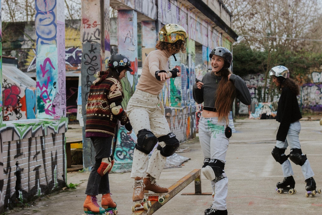 Groupe de filles qui sautent sur un rail pour grinder