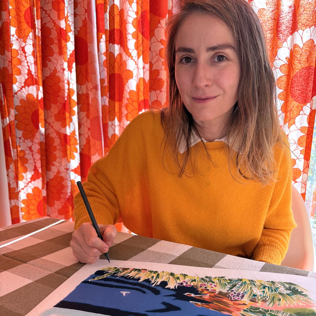 Portrait d’Isabelle Flahault dans son atelier d’illustration, en train de dessiner.