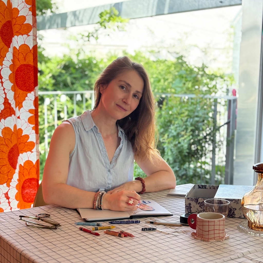Portrait d’Isabelle Flahault dans son atelier d’illustration, en train de dessiner.