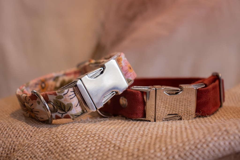 Deux colliers : un collier à fleurs (fleurs beiges, feuilles vertes et feuilles rouges rouilles) sur fond blanc & un collier couleur rouge rouille 