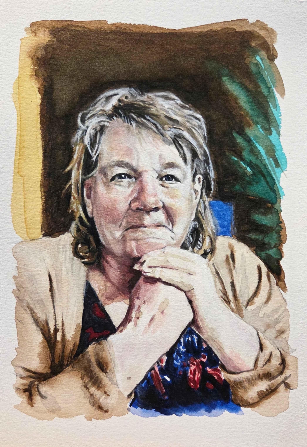Watercolour portrait of a lady sat at a table resting her chin on her clasped hands. Painting as a keepsake for a late family member.