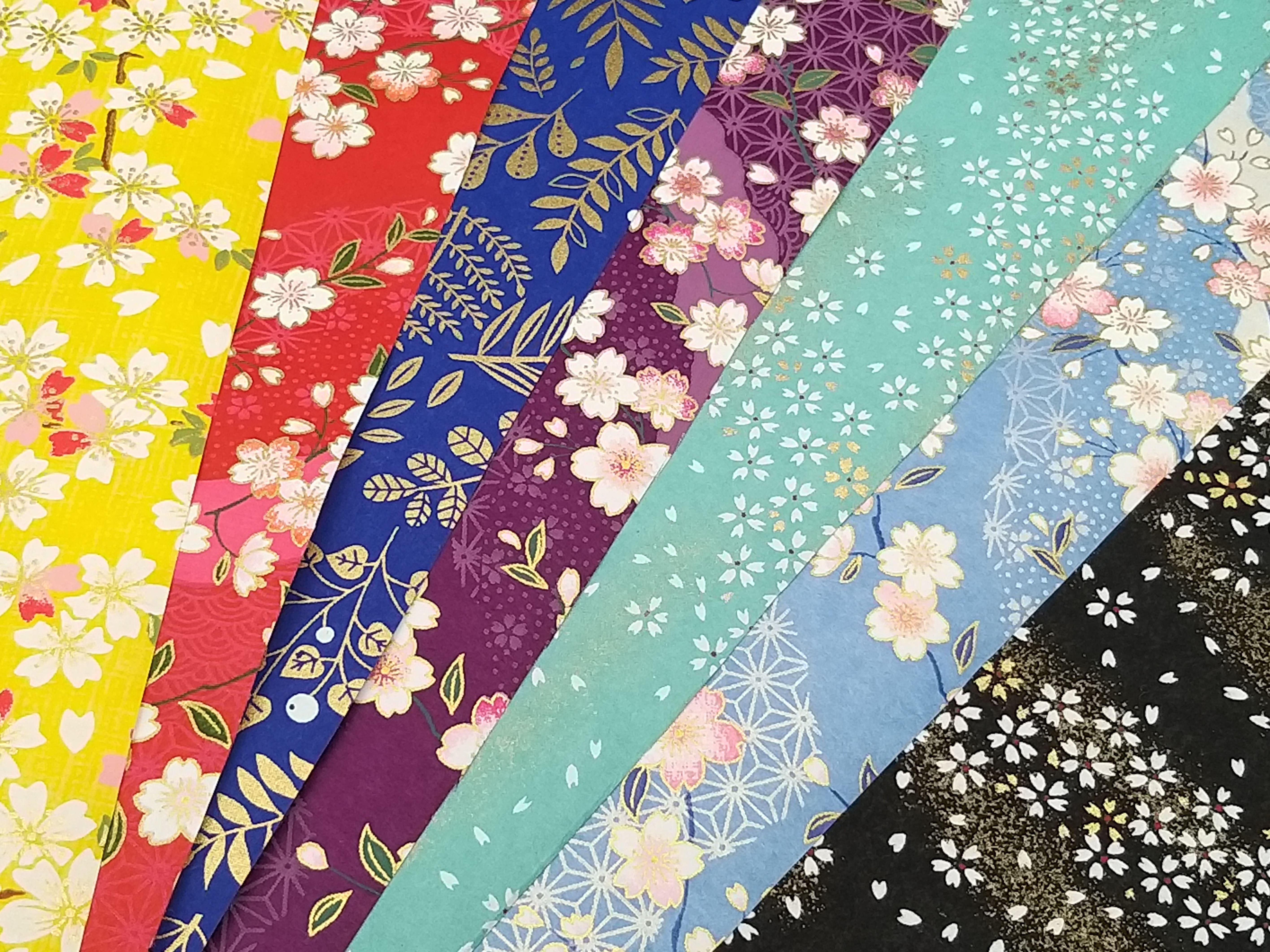 Illustration d'un article de blog : Le papier japonais : l'âme d'une tradition au service de l'élégance". L'image représente plusieurs exemples de papier japonais utilisés pour la fabrication de boucles d'oreilles et sautoir.