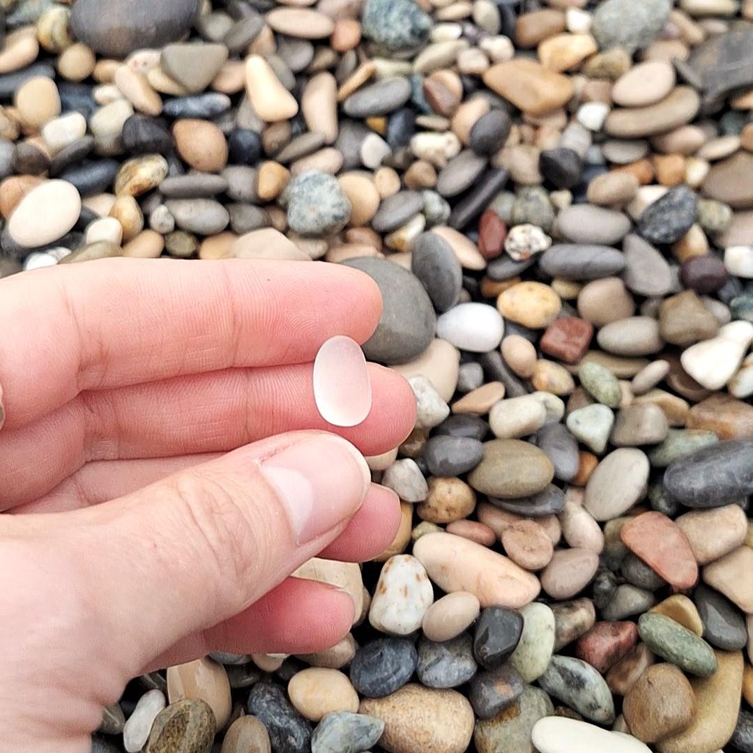 main avec des fragments de verres marins ou beach glass colorés