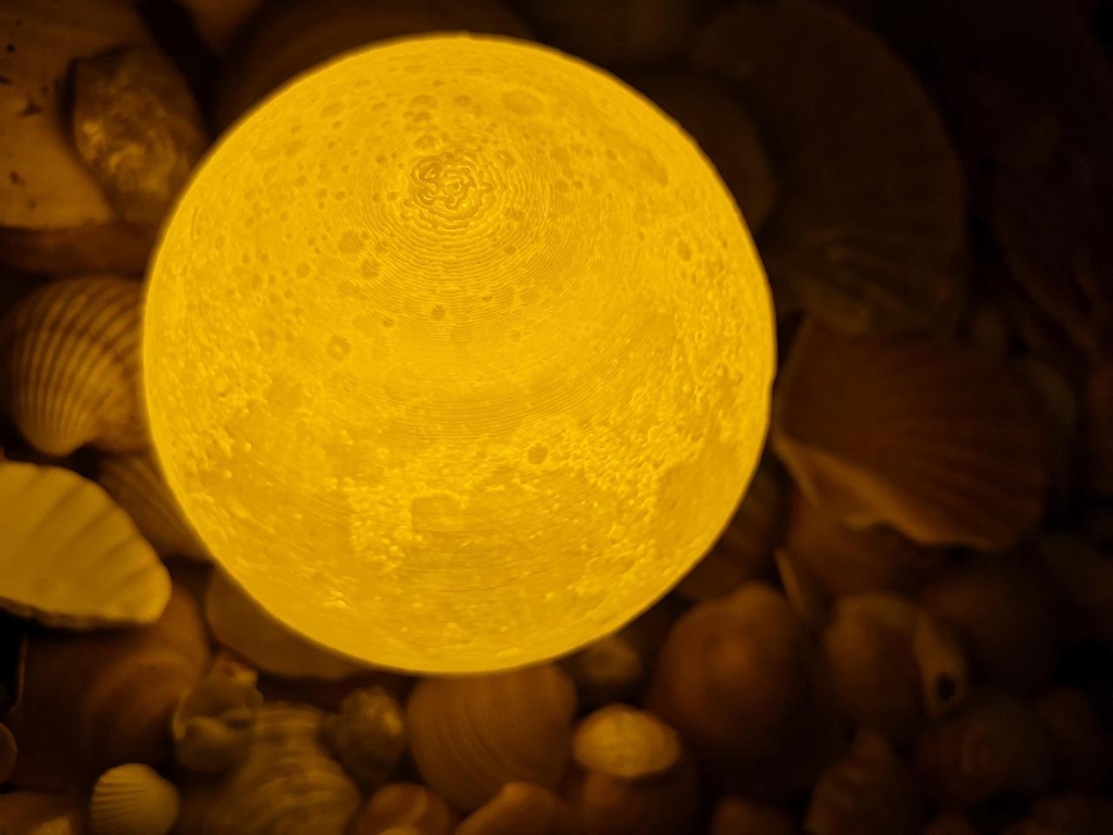 Lune imprimée en 3D laissant transparaître la lumière diffusée de l'intérieur.