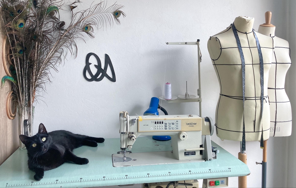 Atelier de couture, prise de mesure, mannequin et tissus avec des machines à coudre.