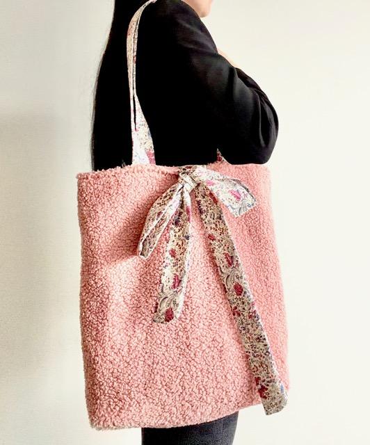 sac cabas en tissu bouclette teddy vieux rose, se ferme avec des bandes à nouer en coton fleuri, deux anses confortables en coton motif fleurs sur fond beige, doublure en coton uni rose