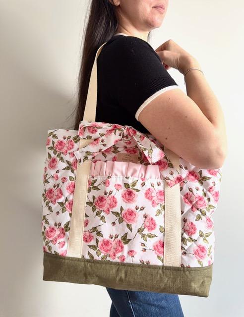 Sac cabas matelassé en coton motif floral roses délicates et fond de sac en lin vert mousse clair, une poche à l'extérieur ornée  d'un froufrou, le sac se ferme par 2 liens à nouer au même tissu fleuri.