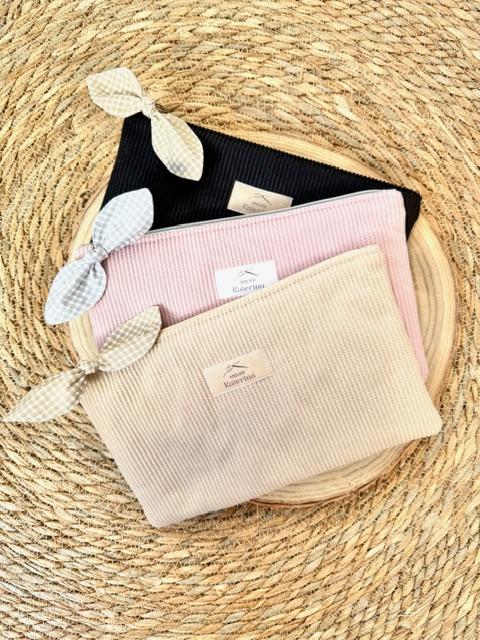 pochettes plates zippées en velours côtelé avec un noeud sur le tiret du zip.
