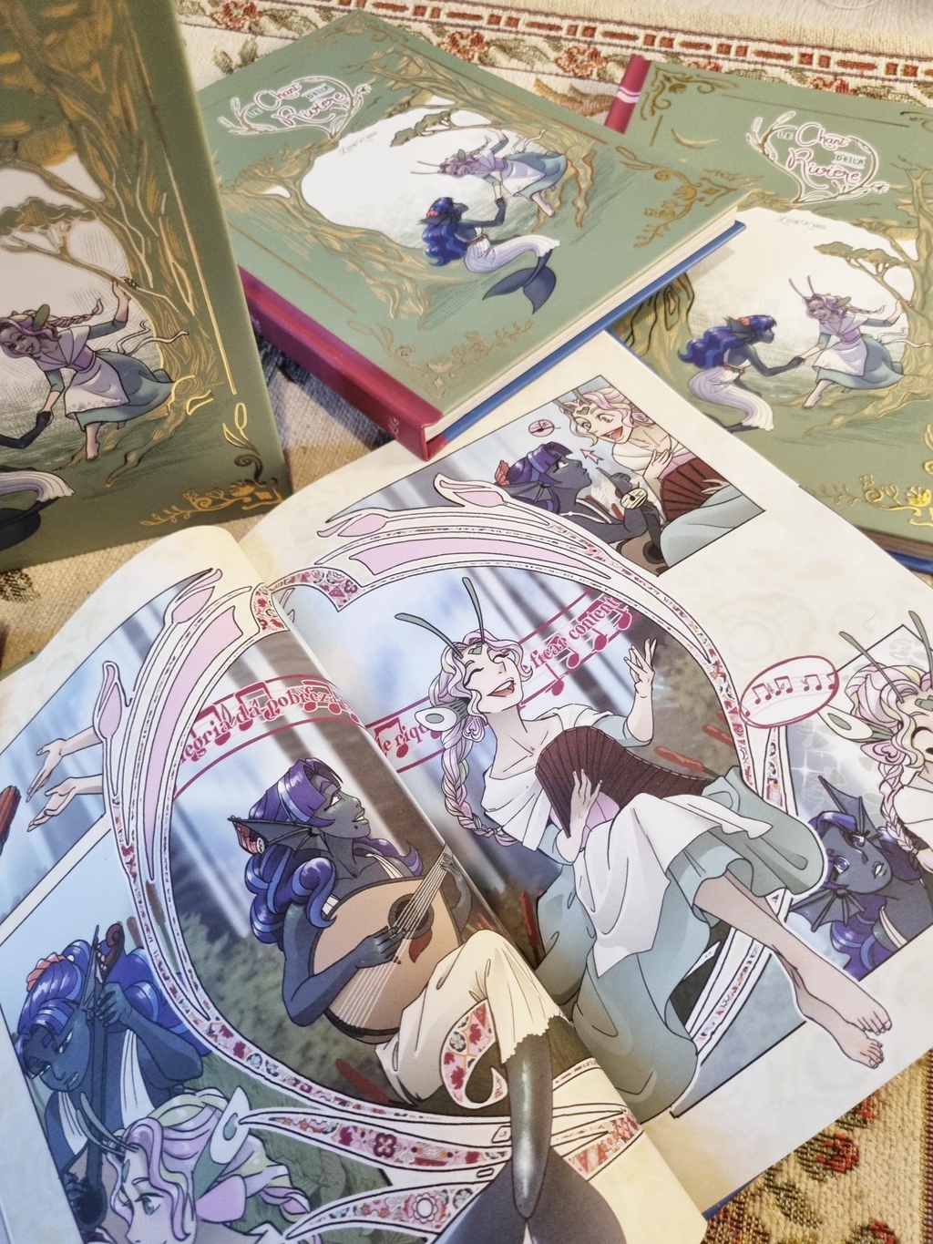 Double page du livre Le Chant de la Rivière représentant la fée qui chante et la sirène qui joue de la guitare.