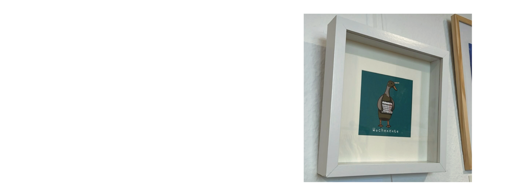 Eingerahmter Mini-Print von einer illustierten Ente, die einen Kalender hält, mit dem Schriftzug "Wochenente".