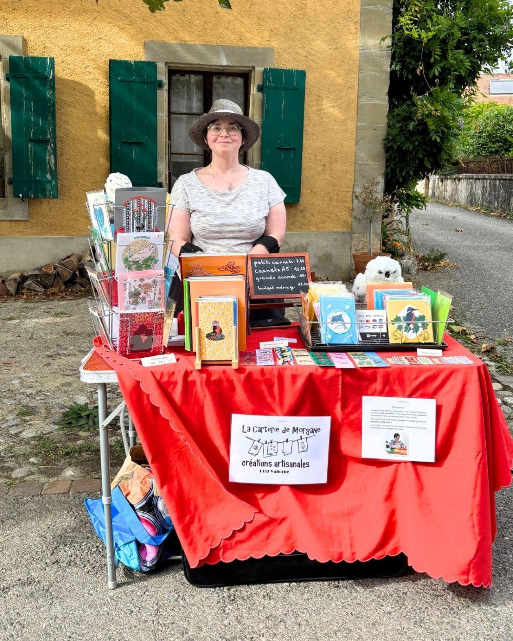 Venue de Vallorbe, je suis sur cette photo au marché artisanale de Vufflens-la-Ville en août 2026. La nappe se soulève, car il y avait du vent.