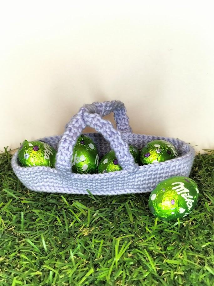 Un panier lilas clair de la collection de Pâques avec des oeufs en chocolat.