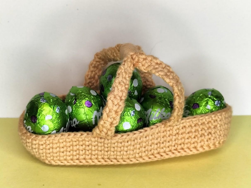 Un panier orange pastel de la collection de Pâques avec des oeufs en chocolat.