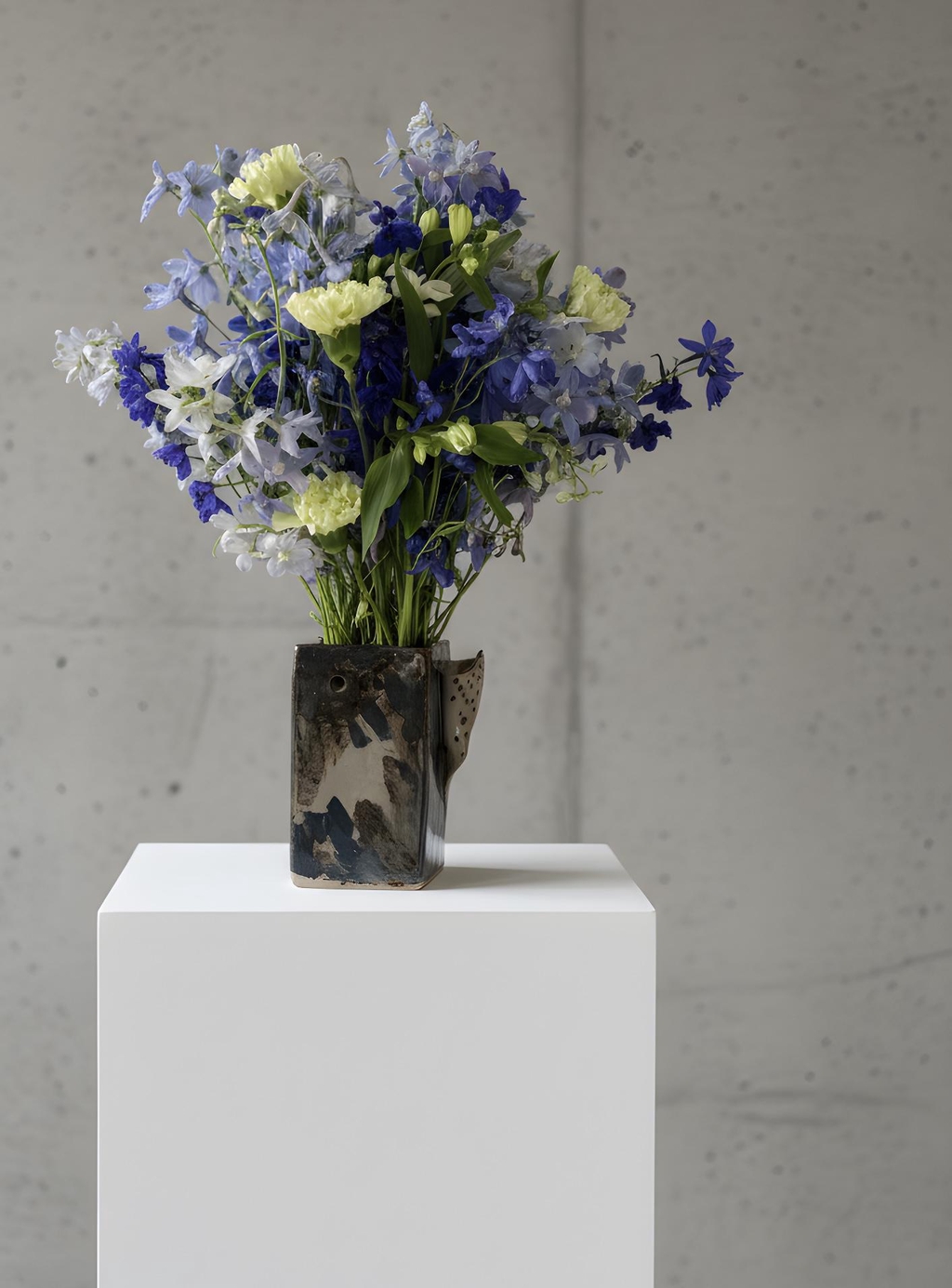 A bunch of delphiniums in a pottery vase