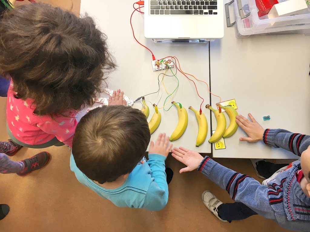 Children using the Makey Makey with bananas.