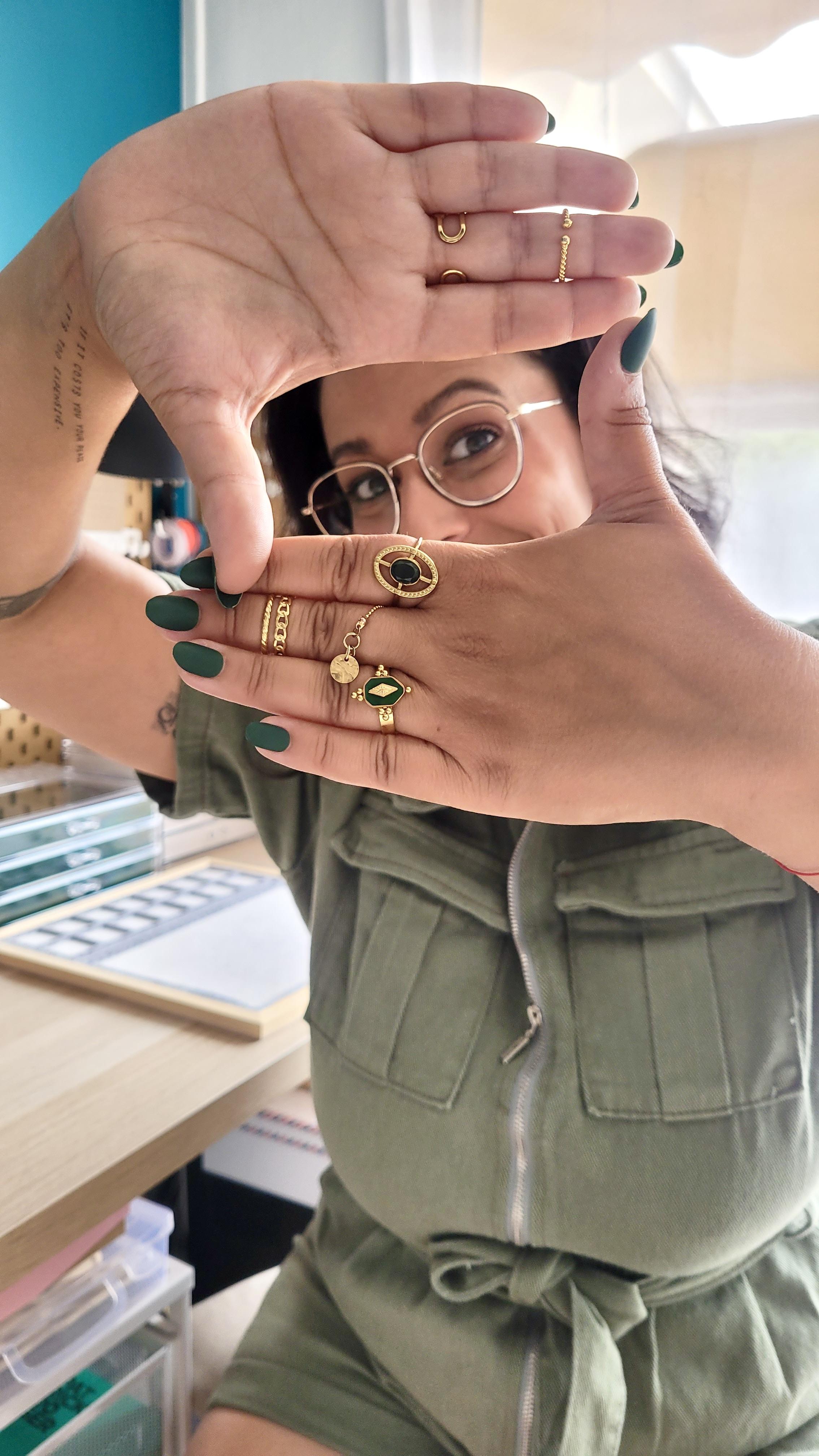 Portrait artistique de la créatrice de bijoux artisanaux, laissant apparaître uniquement ses yeux entre ses deux mains jointes. Une image symbolique qui reflète l’authenticité, la sensibilité et l’inspiration instinctive derrière chaque bracelet fait main. Un regard sur l’univers d’une marque française inspirée par la nature et les émotions