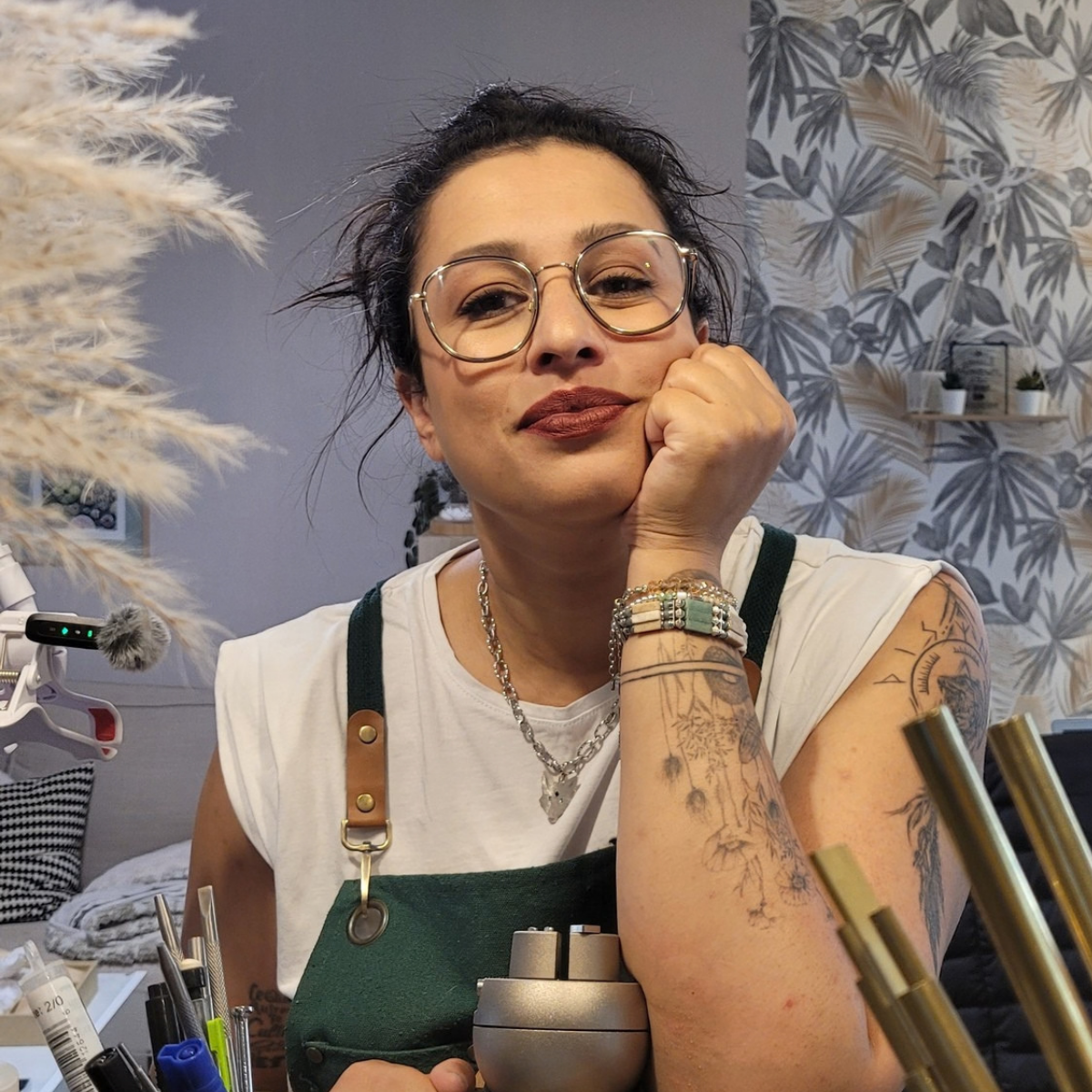 Heidi, créatrice de bijoux artisanaux et fondatrice d’État Sauvage Bijoux, posant devant son atelier et ses outils