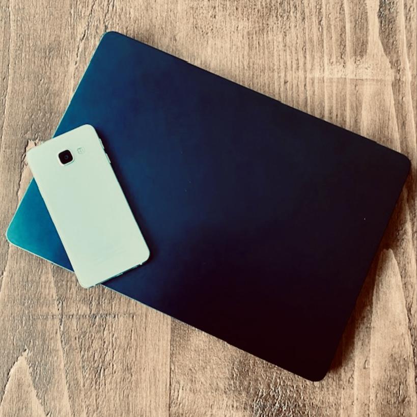 A laptop and mobile phone on a wooden table top