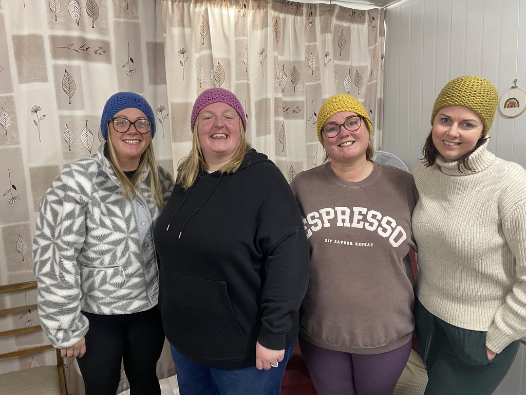 Group of friends showing off their new beanies at the end of an on-demand learnt to knit workshop.
