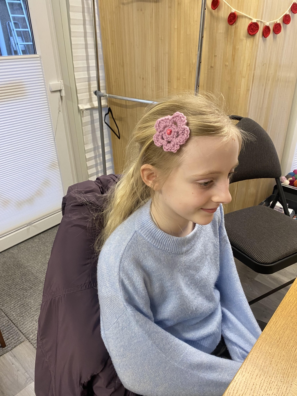 Child displaying their newly crocheted hair clip.