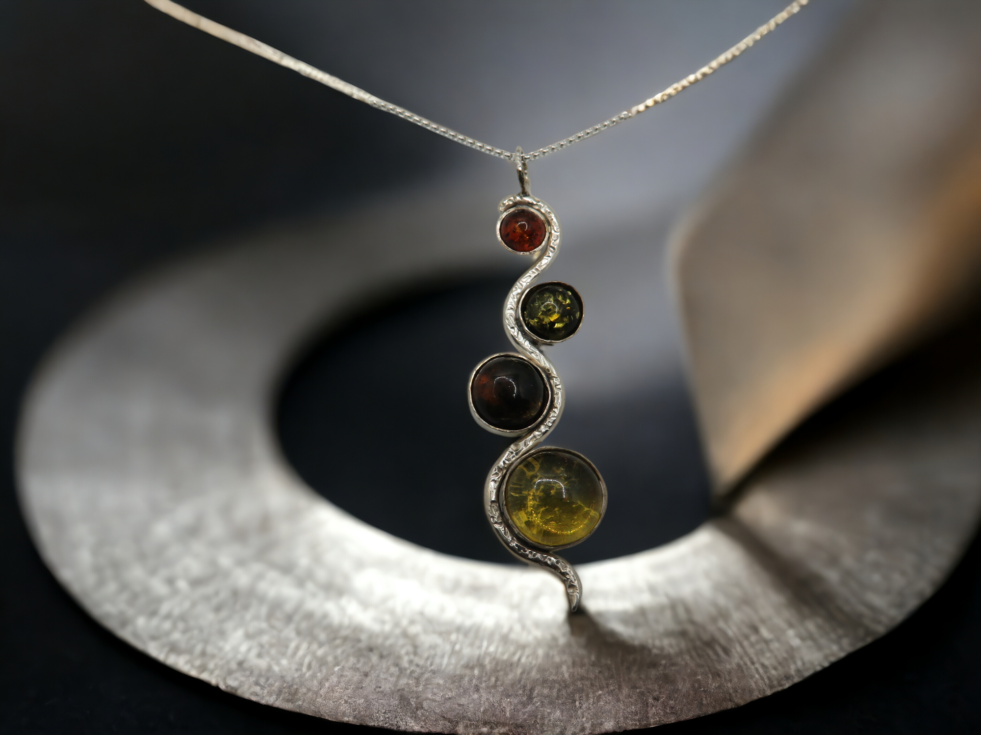 Pendentif en ambre naturel avec inclusion, une pièce unique de la collection Nalafines, évoquant la chaleur et la richesse de la nature dans un éclat d'ambre translucide