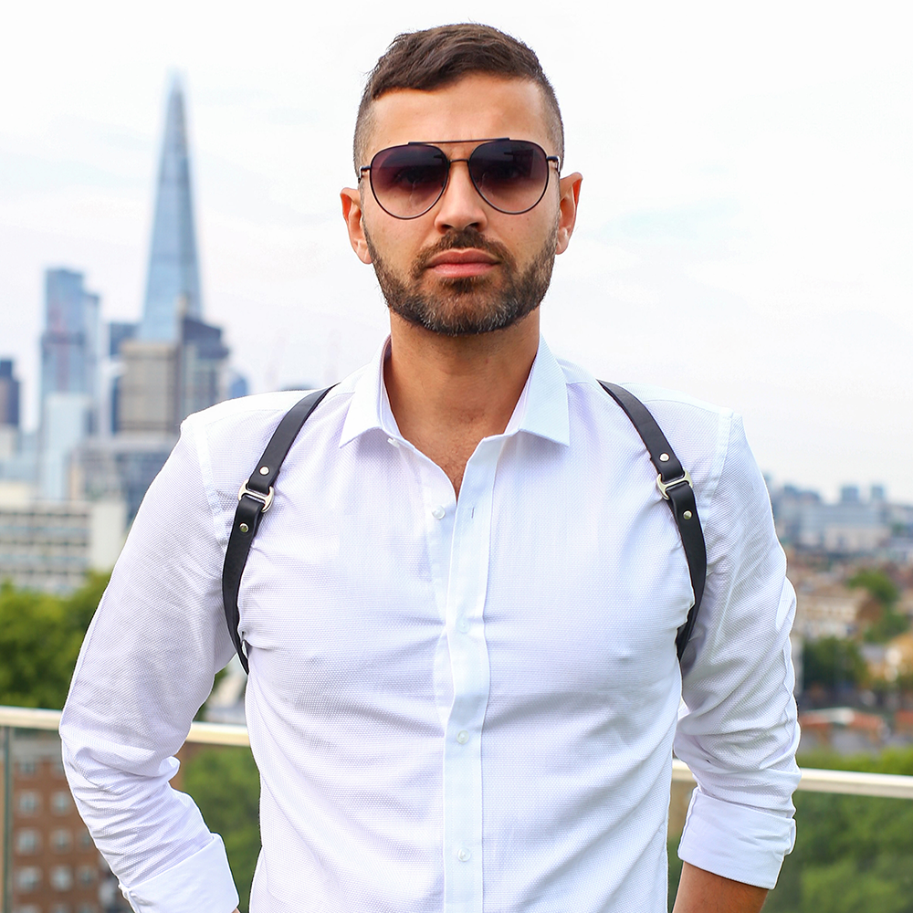 A black leather shoulder harness worn by male model at London location with the Shard Tower in the background