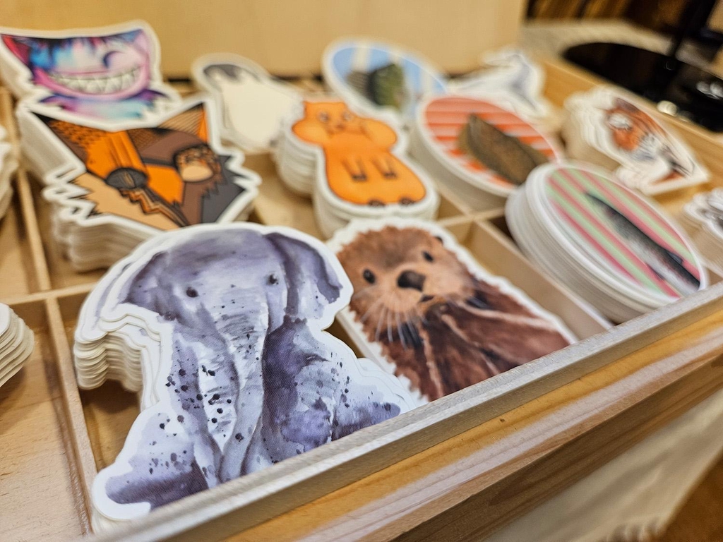 Mit Aquarellfarben gemalte Tiermotive, darunter ein Elefant und ein Otter als Vinylsticker mit weißer Umrandung. 