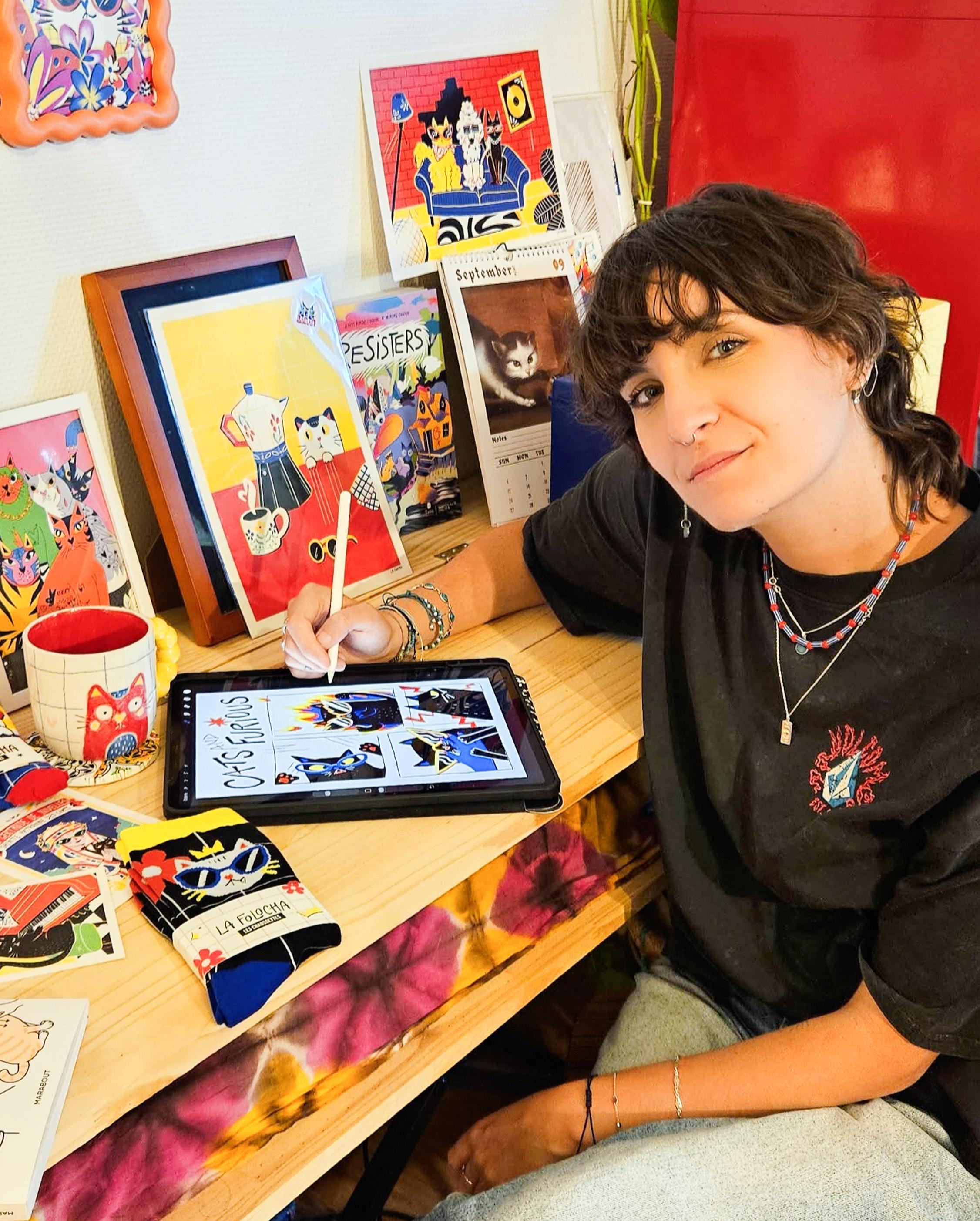 Emeline La Folocha qui pose avec ses illustrations et son chat
