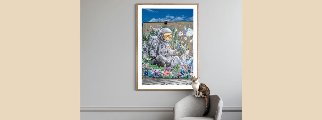 Yuri Catania art print featuring astronaut surrounded by colorful flowers displayed in wooden frame on home wall